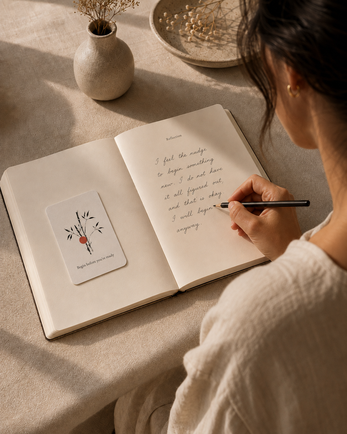 Woman journalling with a meditation card next to her